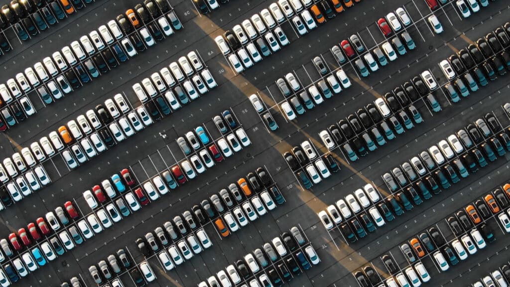 Aerial view of an automotive plant showcasing newly manufactured vehicles ready for distribution.