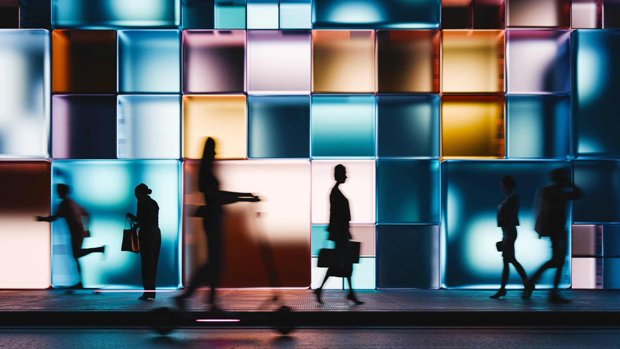 Silhouettes of people walk by a vibrant wall, echoing law firm digital transformation consulting.
