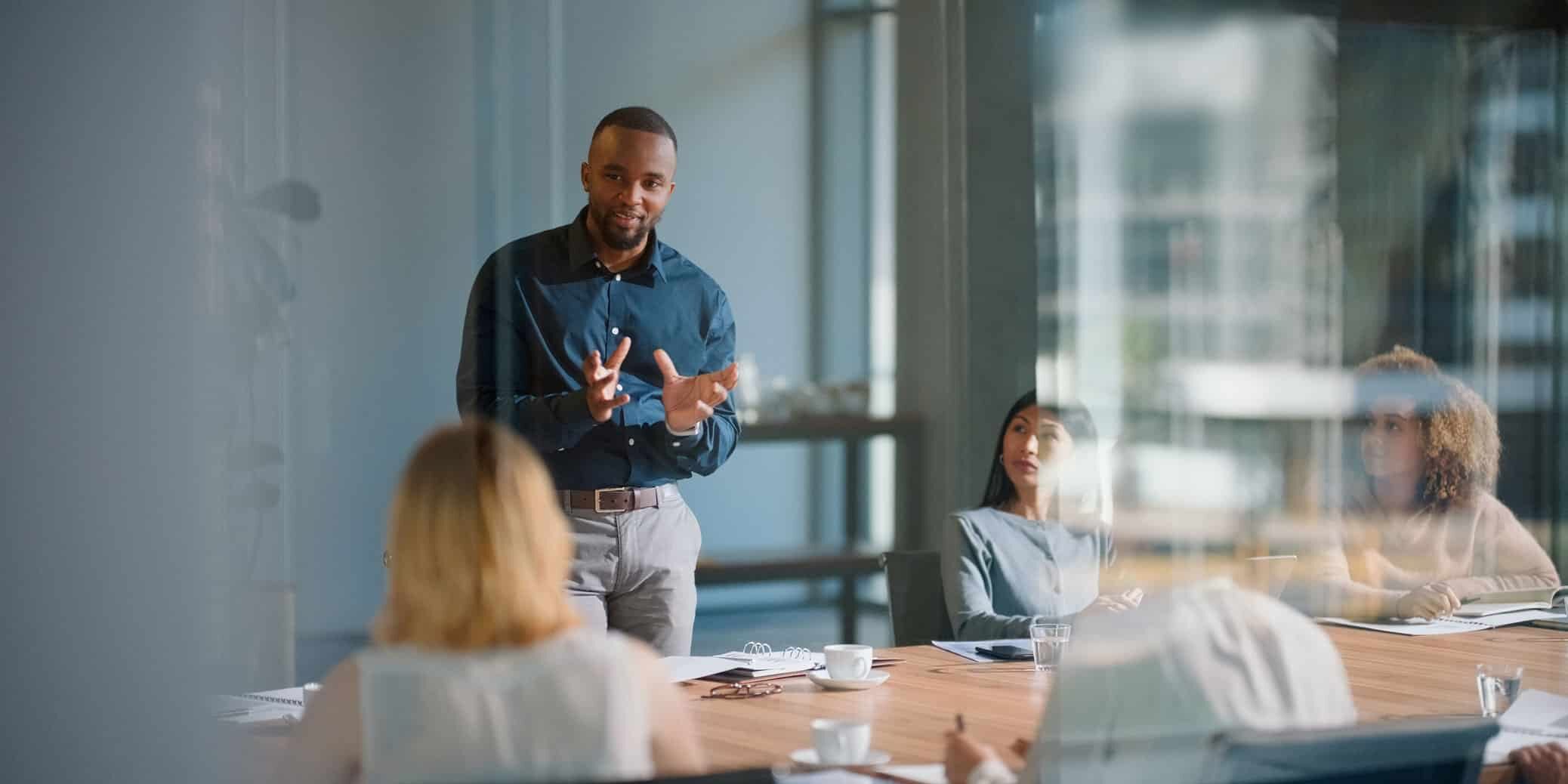 Man presenting Law Firm Strategy & Innovation Consulting to colleagues in a modern conference room.