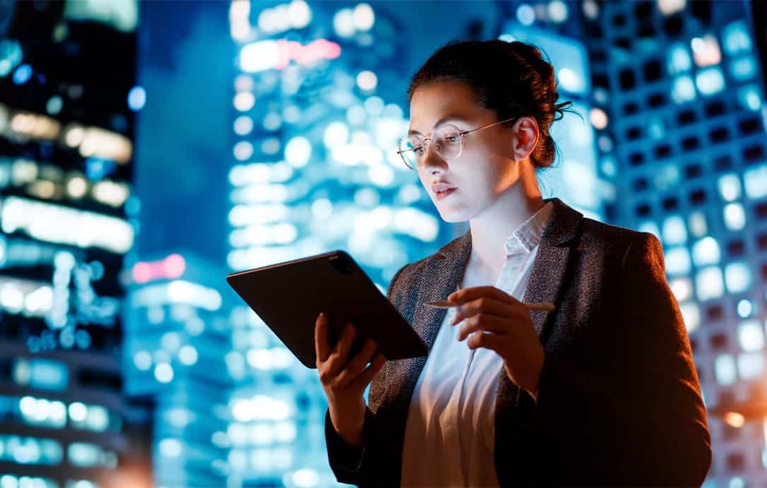 Young businesswoman using tablet pc in the city in the evening.