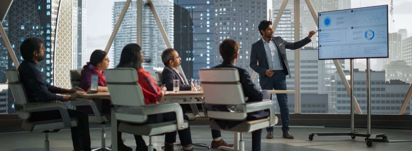 Diverse Conference Room: Young South Businessman Makes a Presentation for Entrepreneurs, Talking, Using TV with Infographics and Statistics.