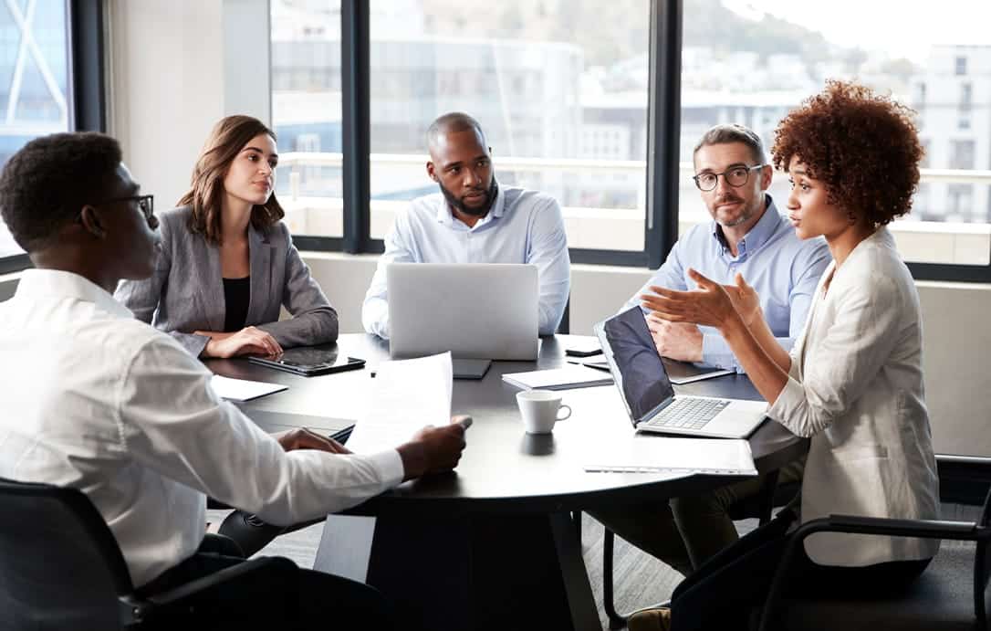 Businesswoman addressing colleagues at a corporate business meeting, close up
