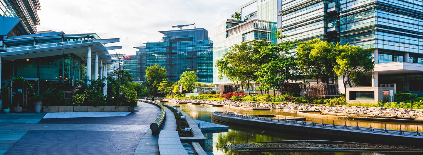 Modern buildings with trees and canal, showcasing CRE Strategy & Innovation Consulting expertise.