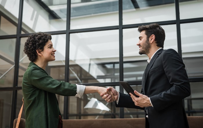 Two people in shake hands, showcasing Travel & Hospitality innovation strategy consulting.