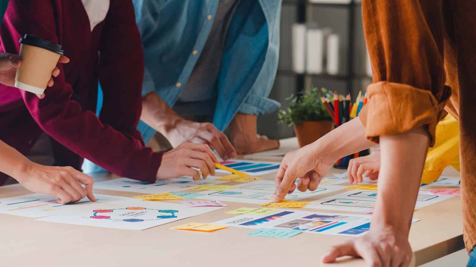 People collaborating at a table, planning a luxury retail strategy & innovation consulting project.