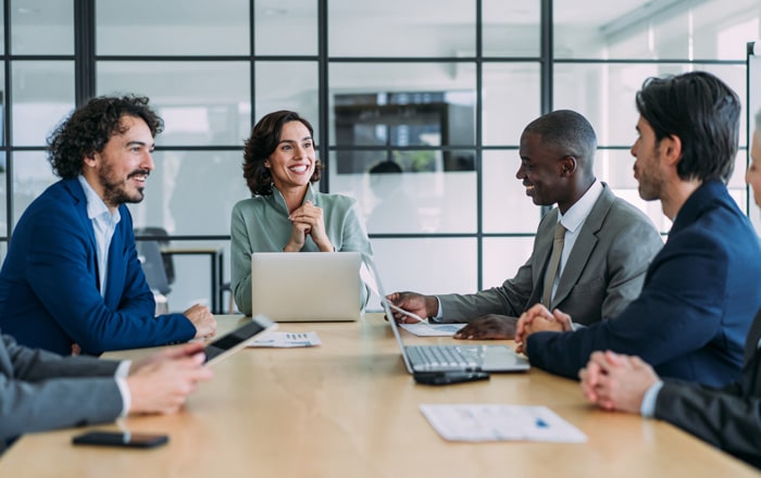 Business people discuss Travel & Hospitality Corporate Performance Consulting at a conference table.