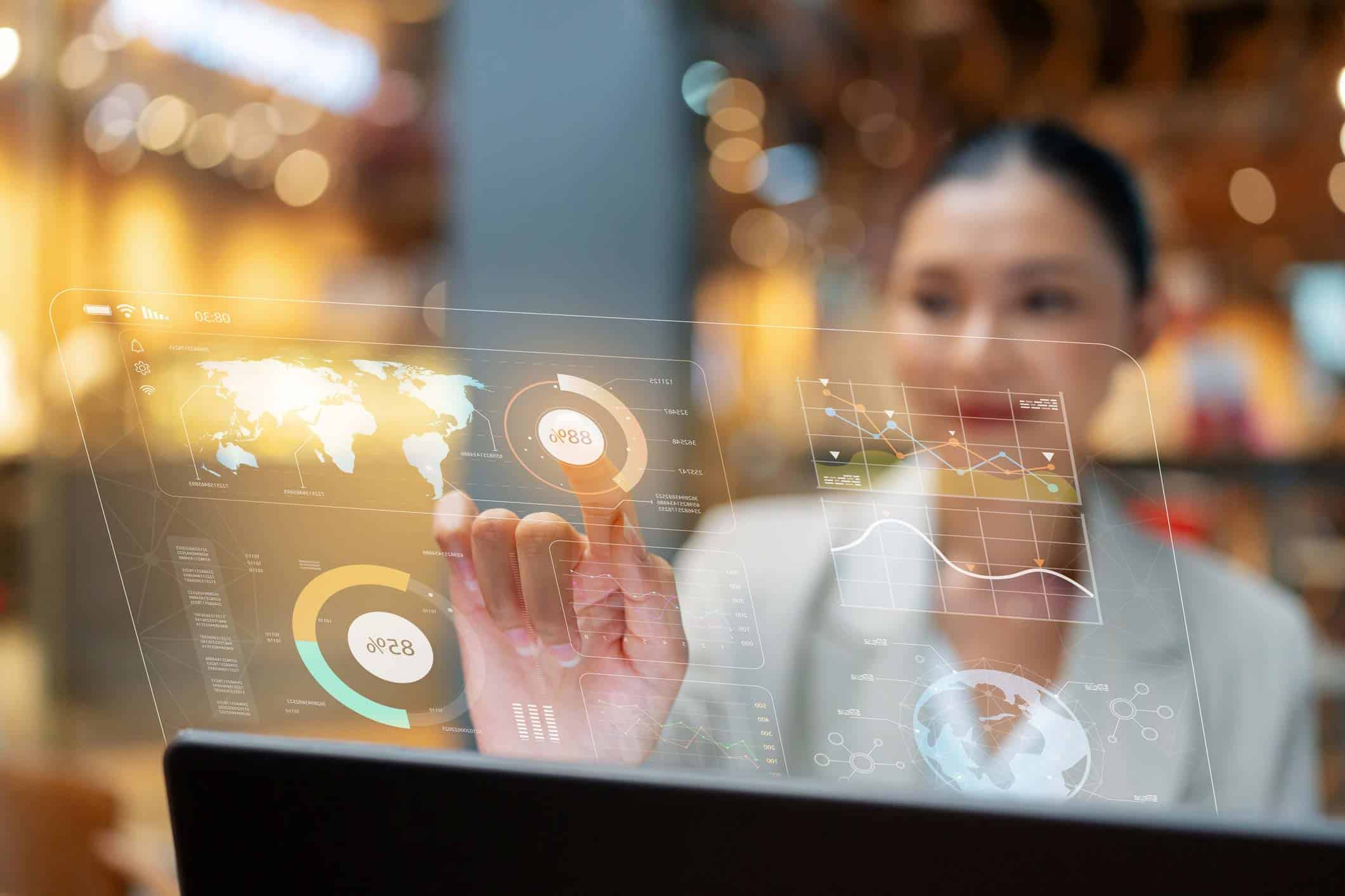 Woman views virtual data graphs on a screen in a Financial Services IT Consulting office.