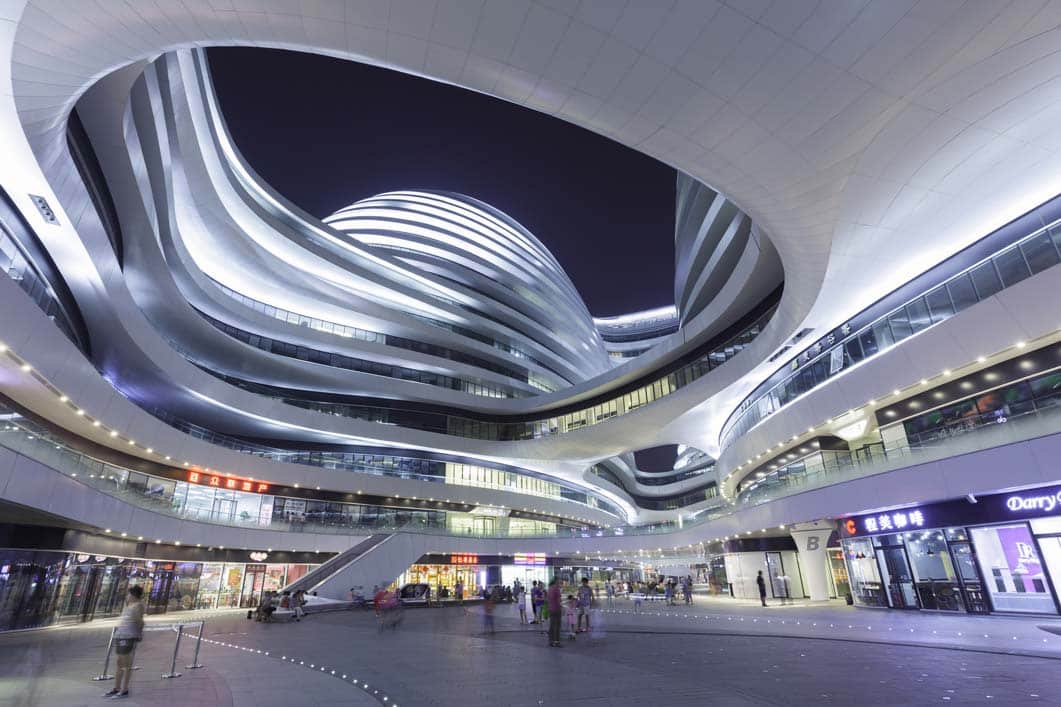 Futuristic white building shines above a luxury retail digital transformation consulting plaza.
