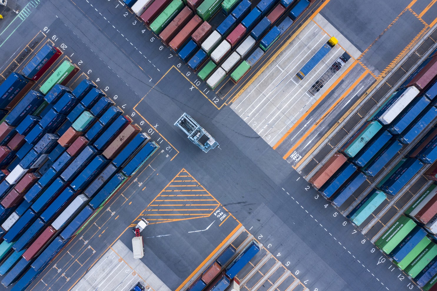 Aerial view of shipping containers and trucks, showcasing global logistic strategy consulting
