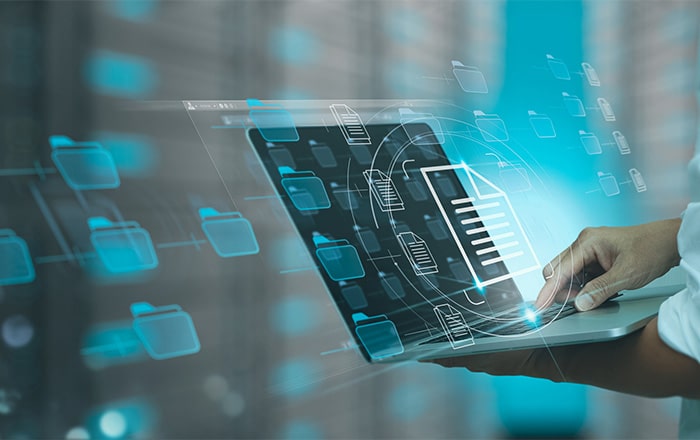 Person on laptop with digital file folders, symbolizing information security consulting.