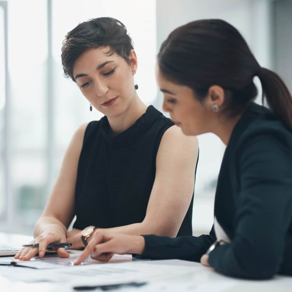 Two women discussing eDiscovery Data Management Consulting at a desk in an office setting.