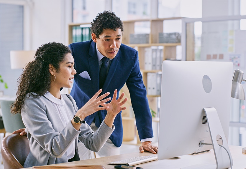 Two colleagues discuss the eDiscovery document review process in a modern office setting.