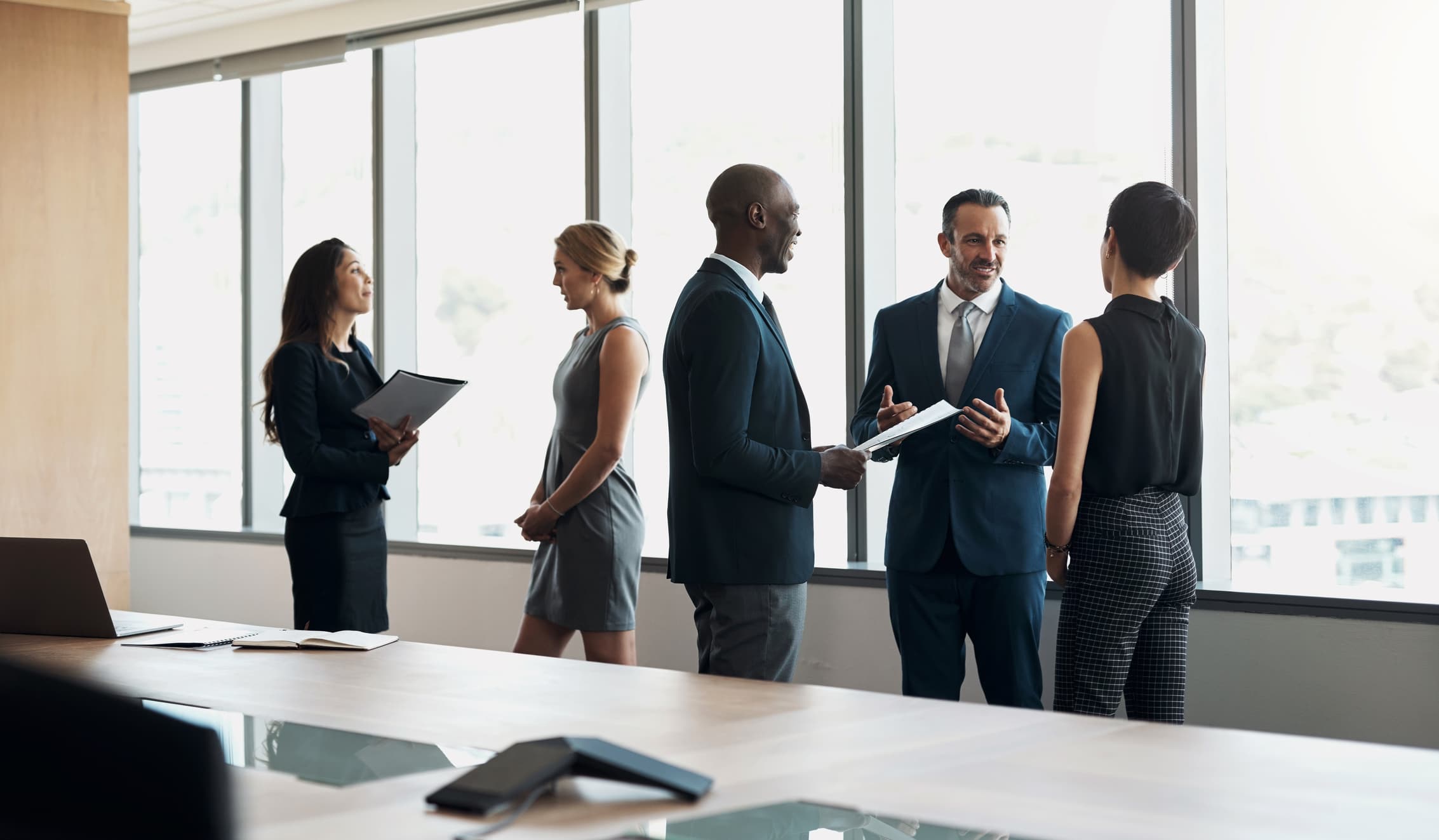 Business professionals collaborating at a modern office table with charts and documents