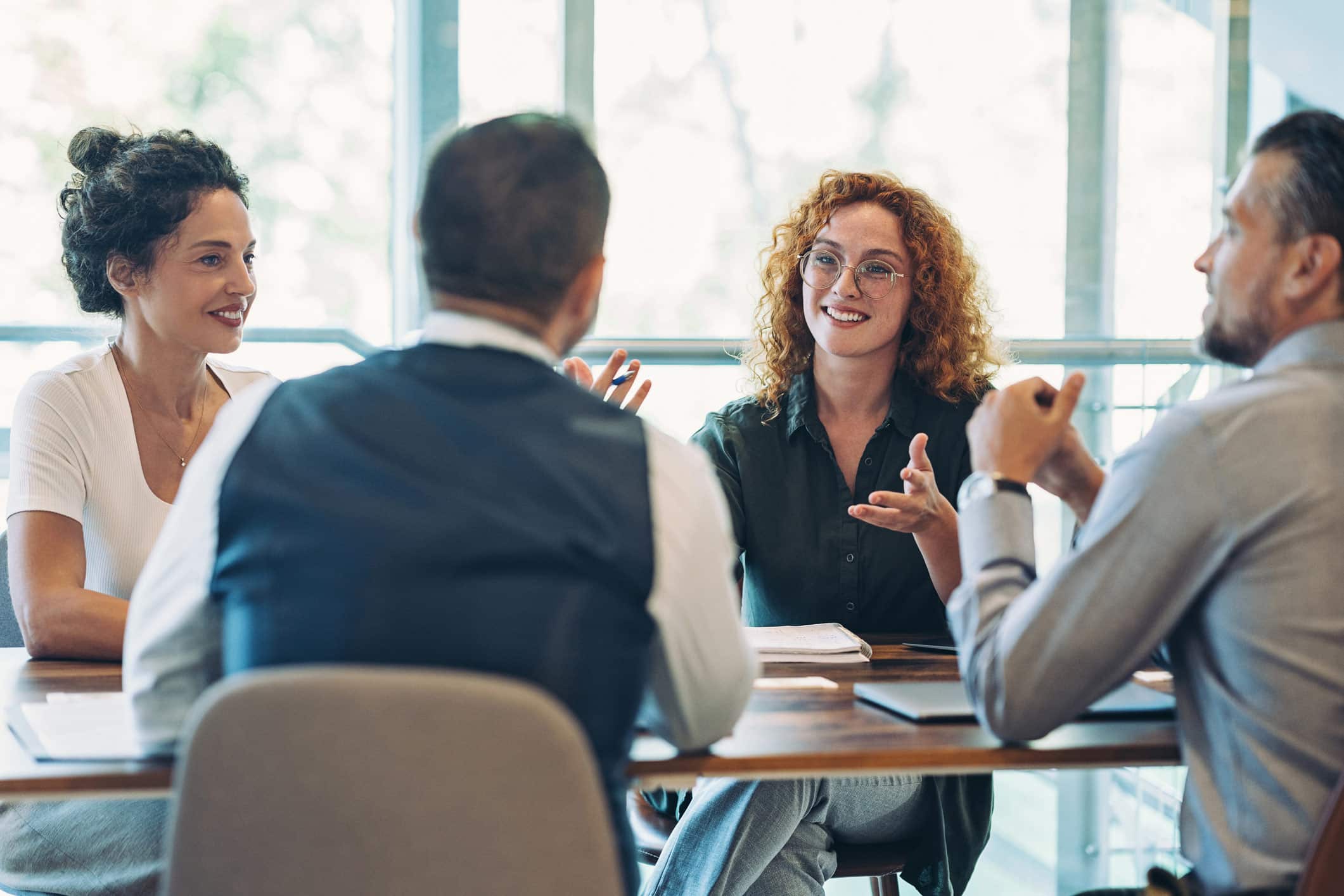 Four people discuss Securities Litigation in a bright, modern office setting.