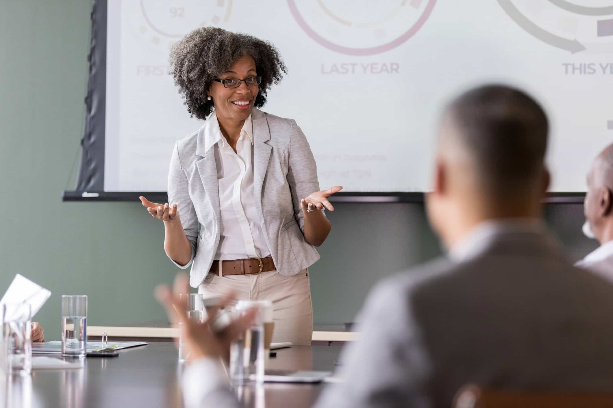 Woman presenting Law Firm BPM Change Enablement to colleagues, charts displayed behind her.