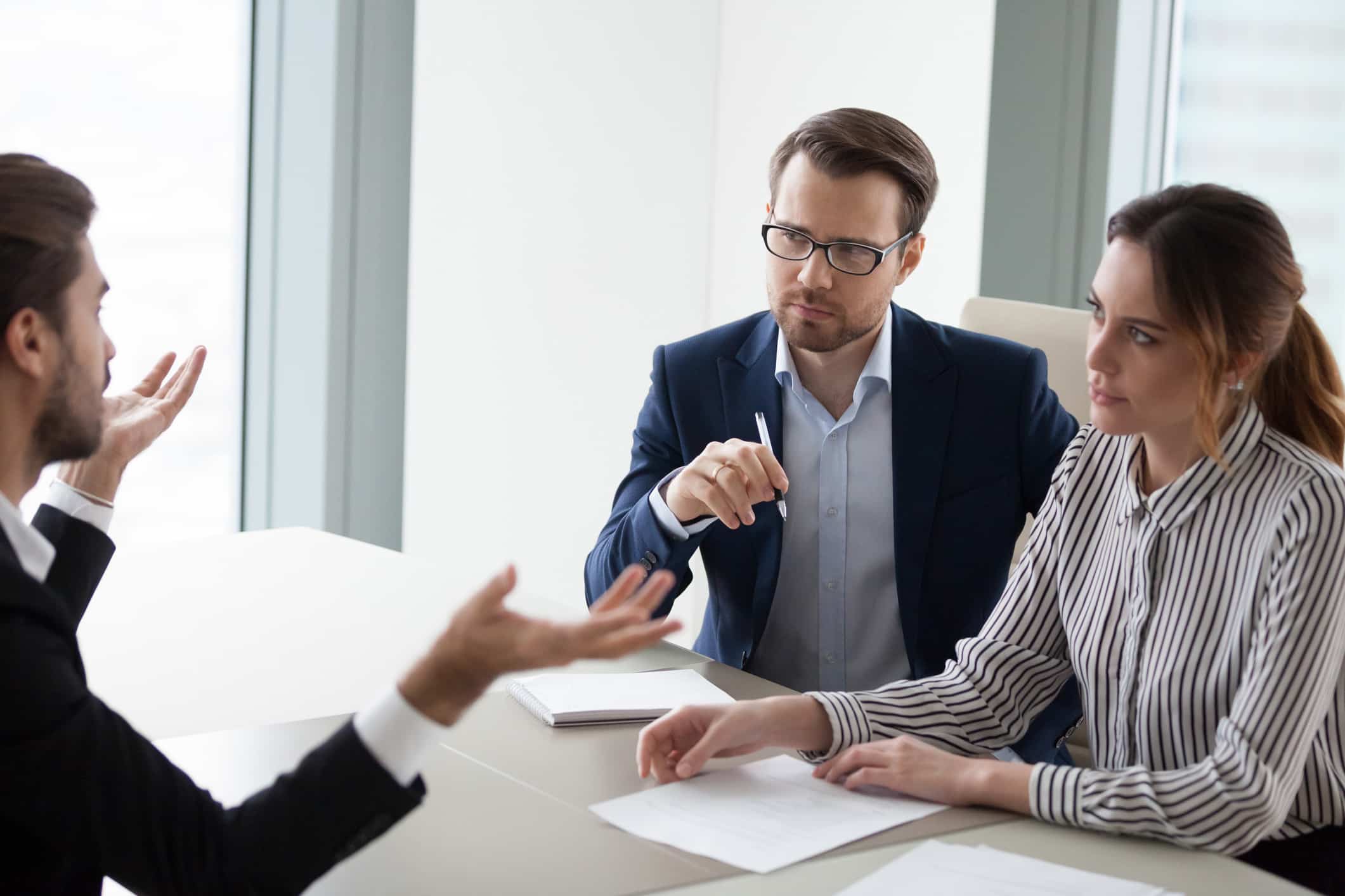 Three people in a business meeting as one discusses TAR Consulting Services.