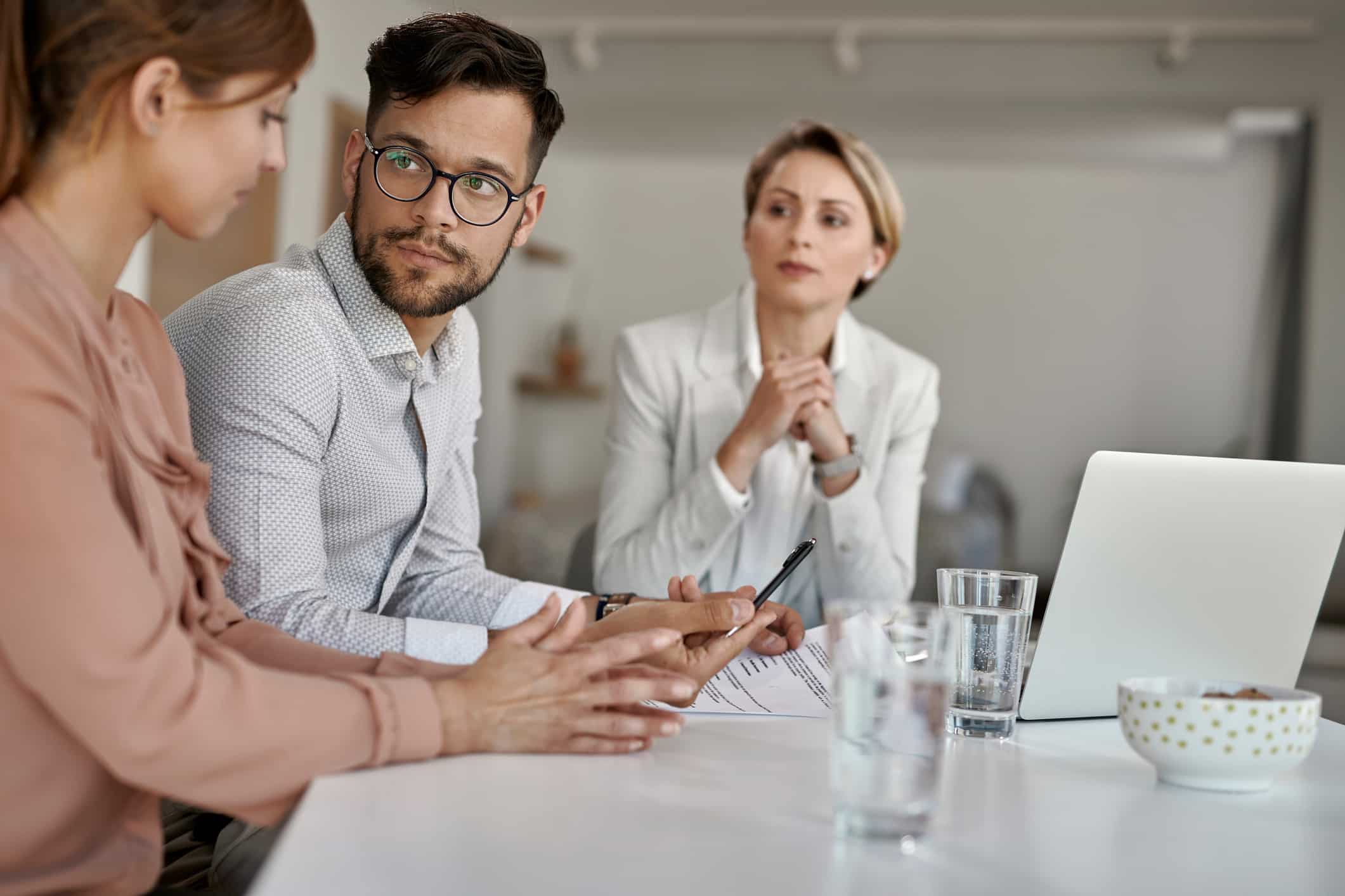 Three people discuss eDiscovery Document Review during a serious business advisory meeting.