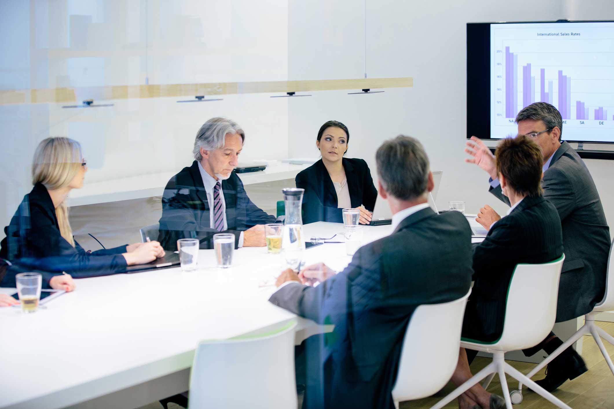 Six business professionals discuss a cyber incident response advisory in a meeting room.