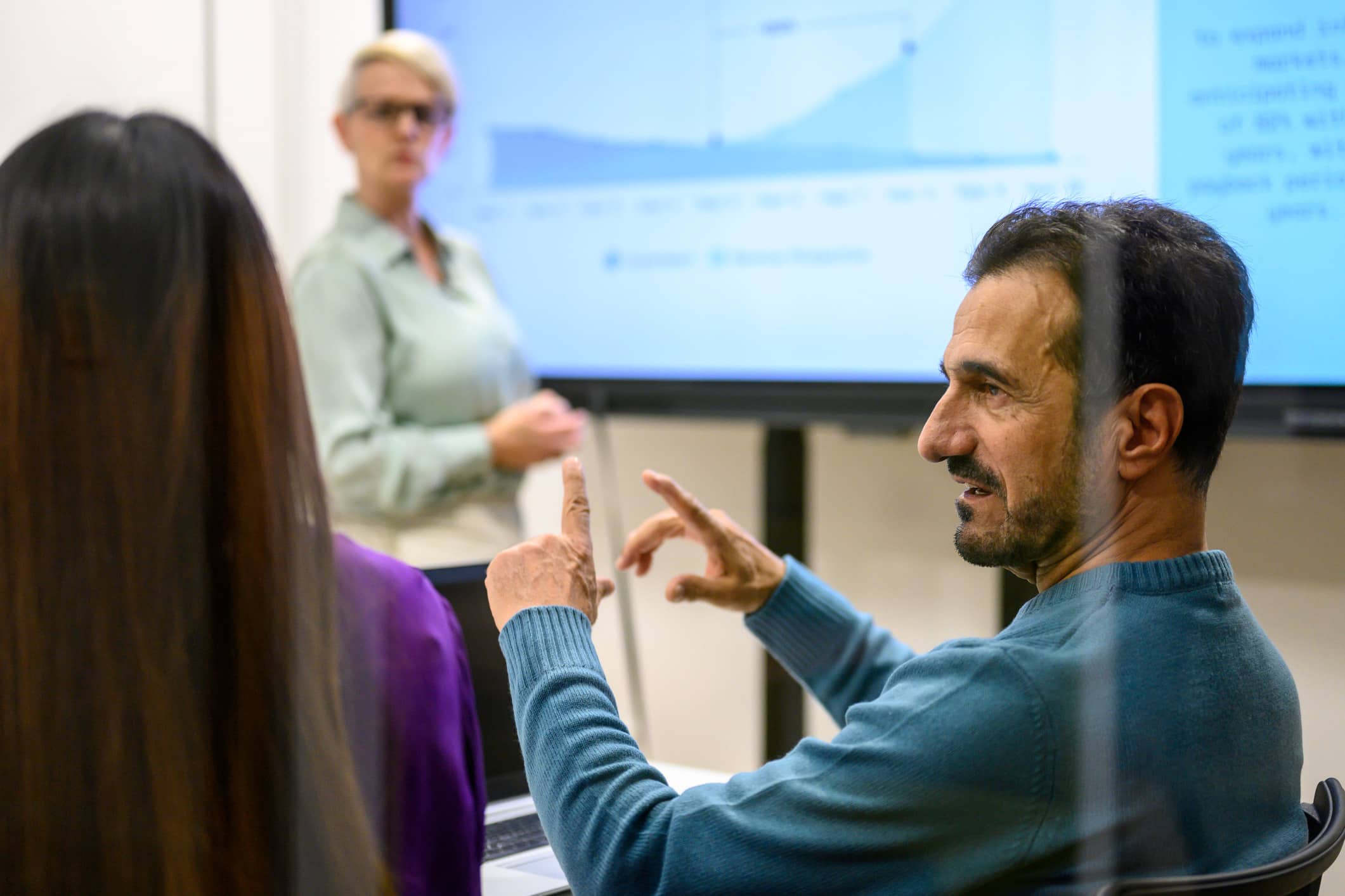 Man gesturing as a woman presents a graph—ideal for eDiscovery Project Management Advisory.
