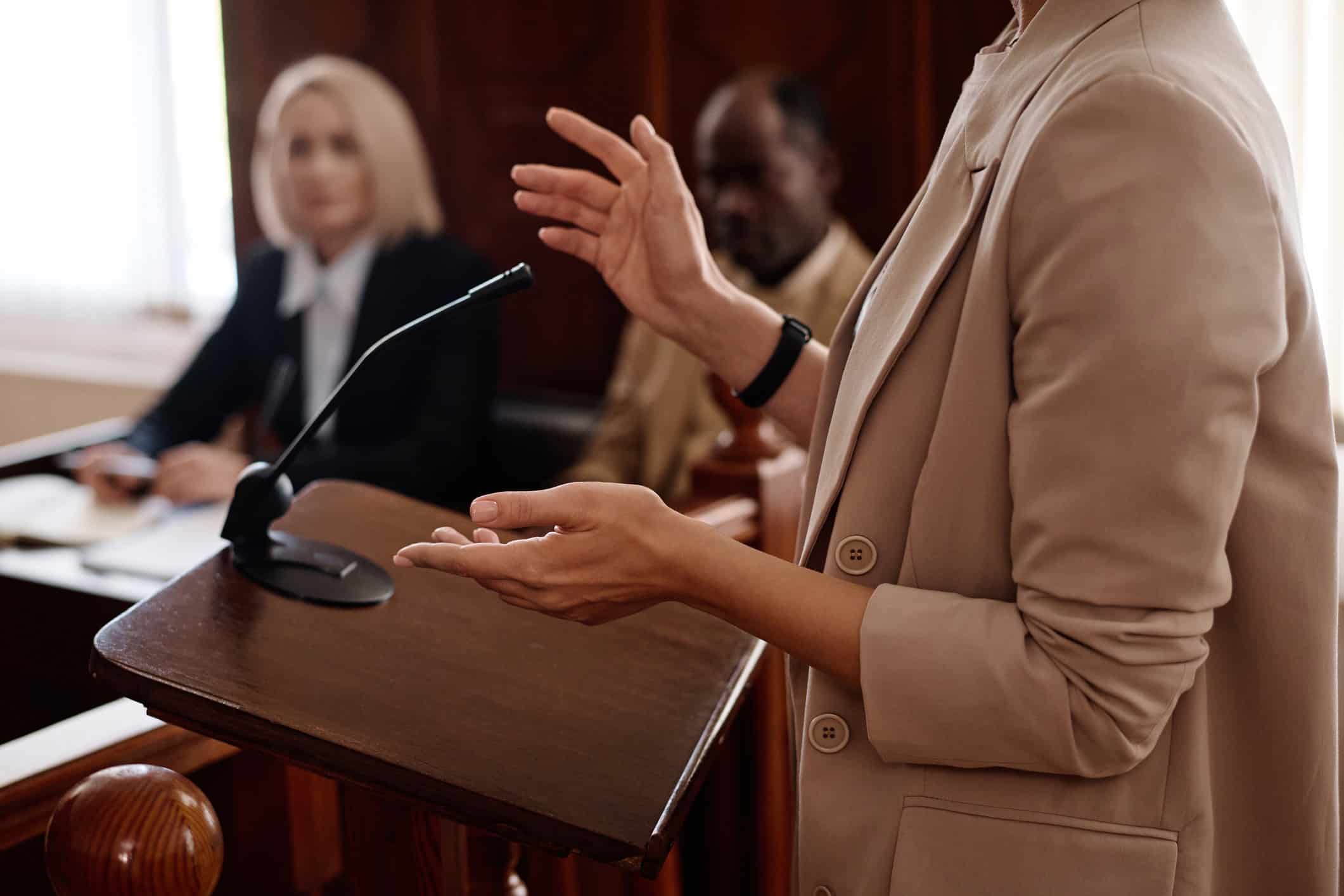 Person speaking at a courtroom podium, highlighting key Trial Strategy Advisory points.