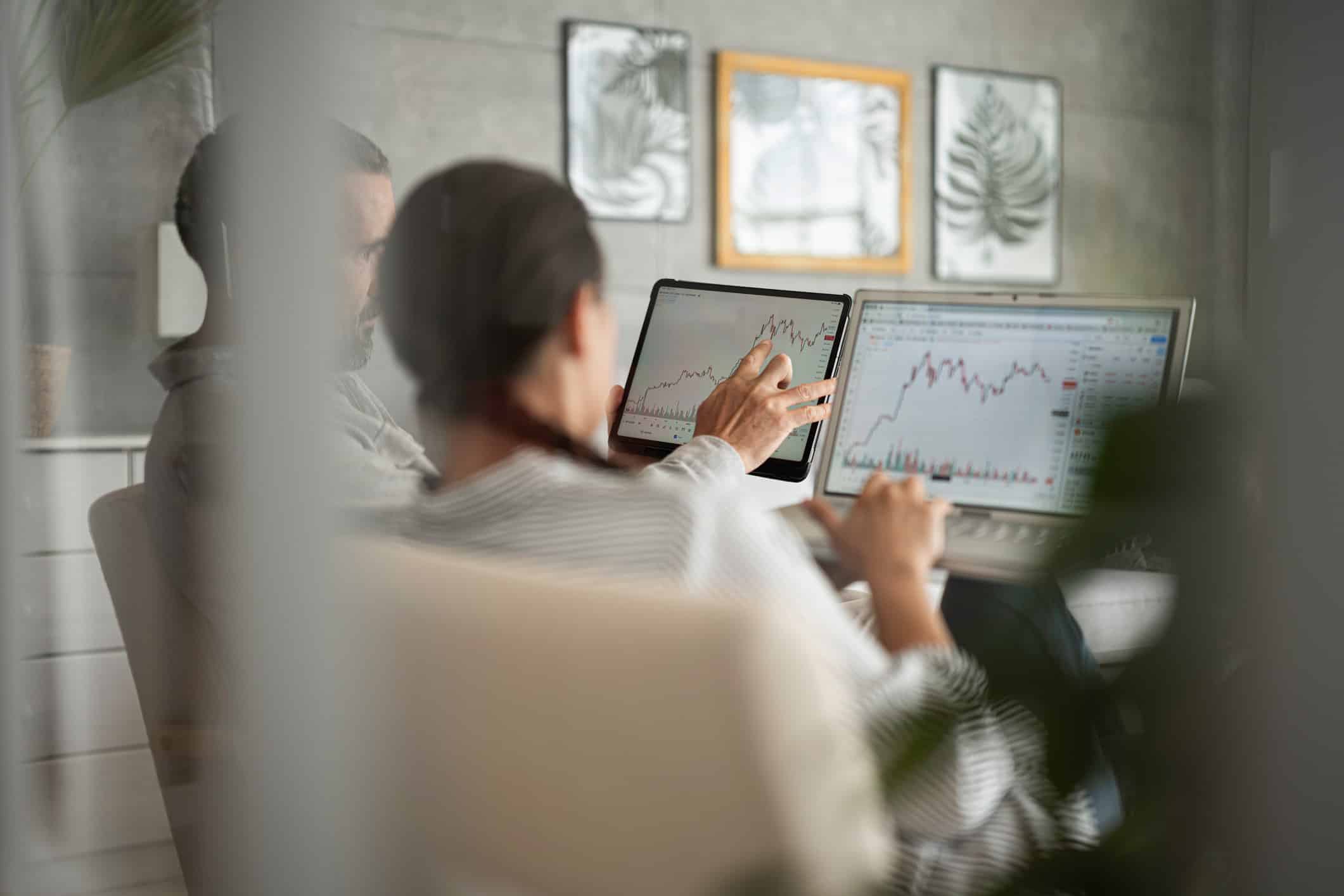 Two people preparing for witness preparation while analyzing financial charts in an office.