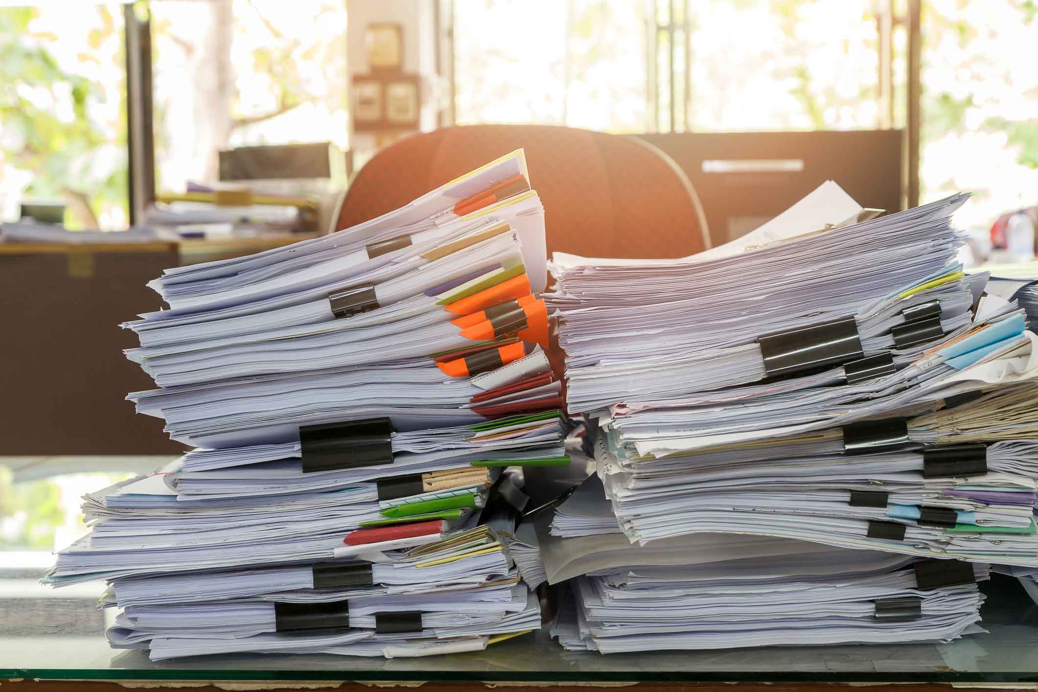 Stacks of paper documents clipped together hint at a need for Continuous Active Learning Consulting.