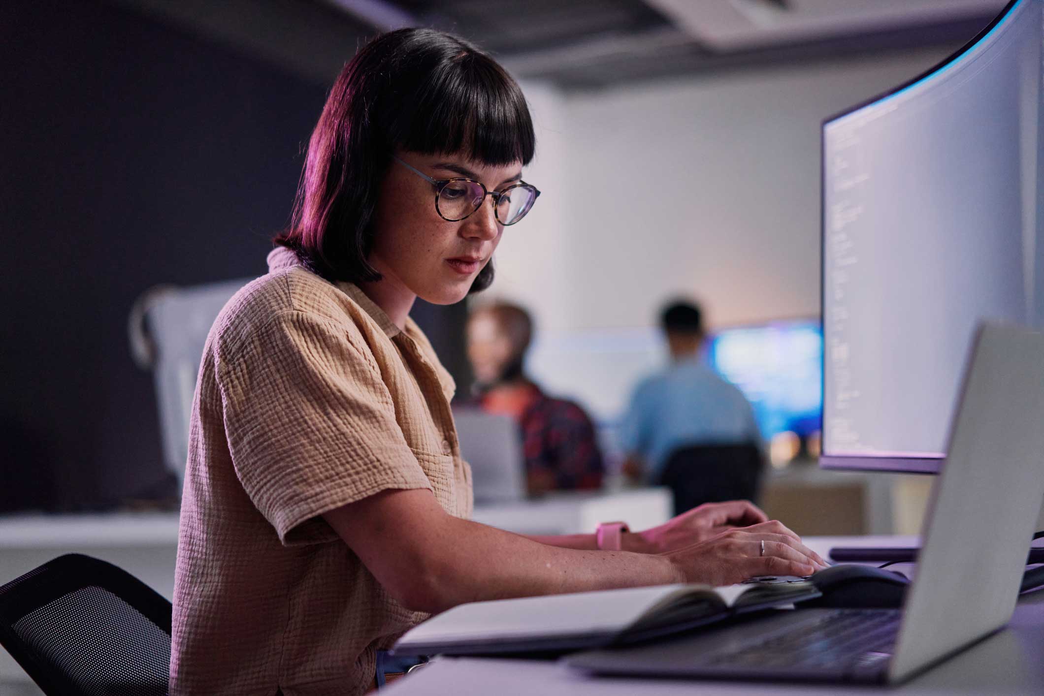 Woman with glasses at desk using AI Legal Document Analysis for a consulting firm.