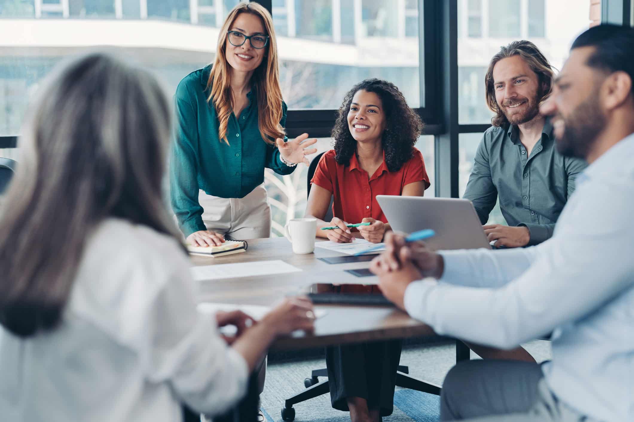 Five people discuss Modern Data Architecture Integration at a meeting table in a bright office.