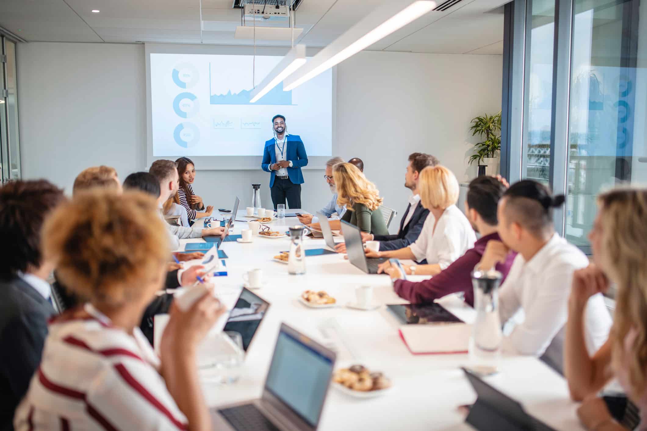 Man presenting a slideshow on Law Firm Marketing Execution in a modern conference room meeting.