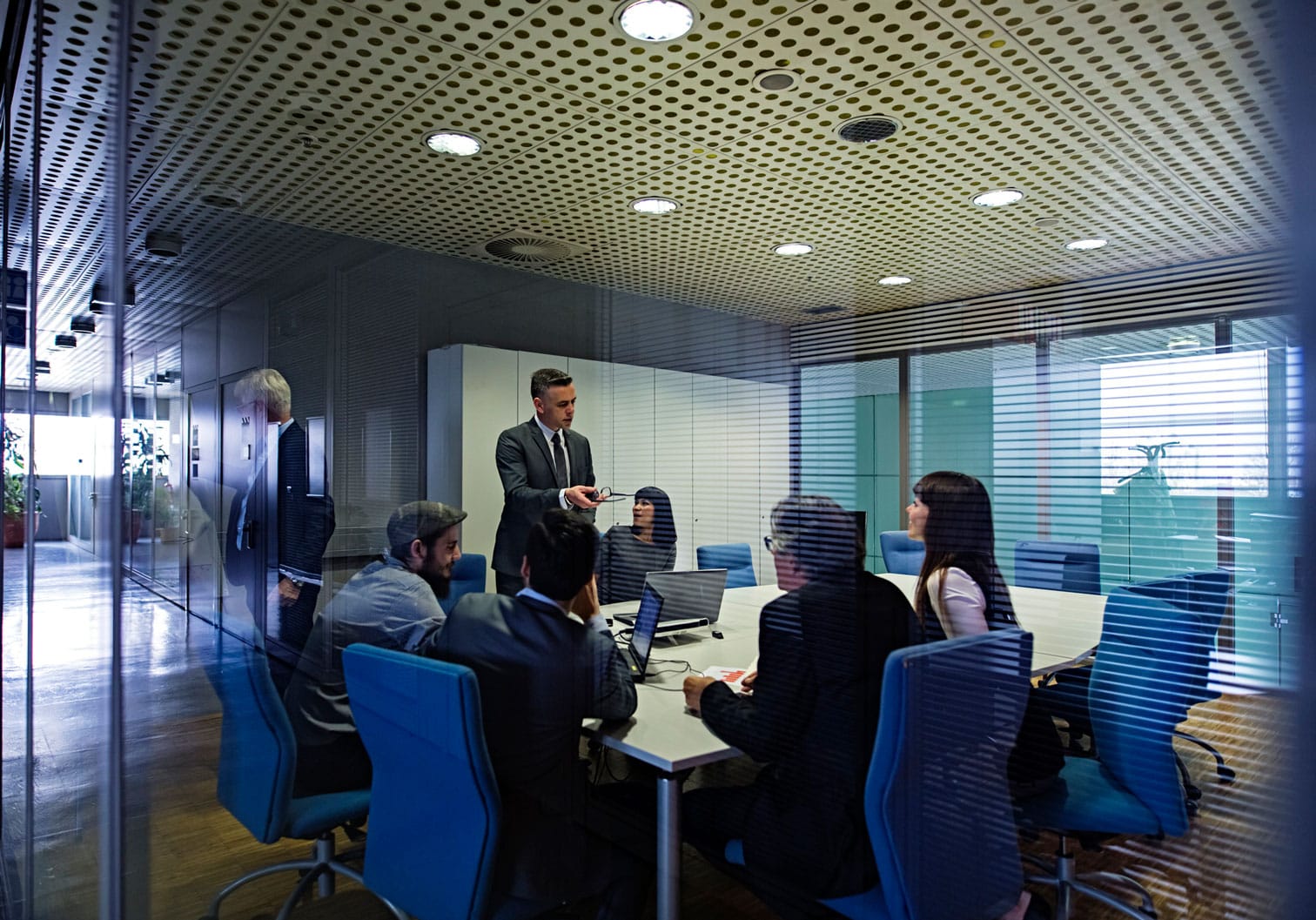 Business meeting in a modern glass-walled room discussing Data Governance Execution.