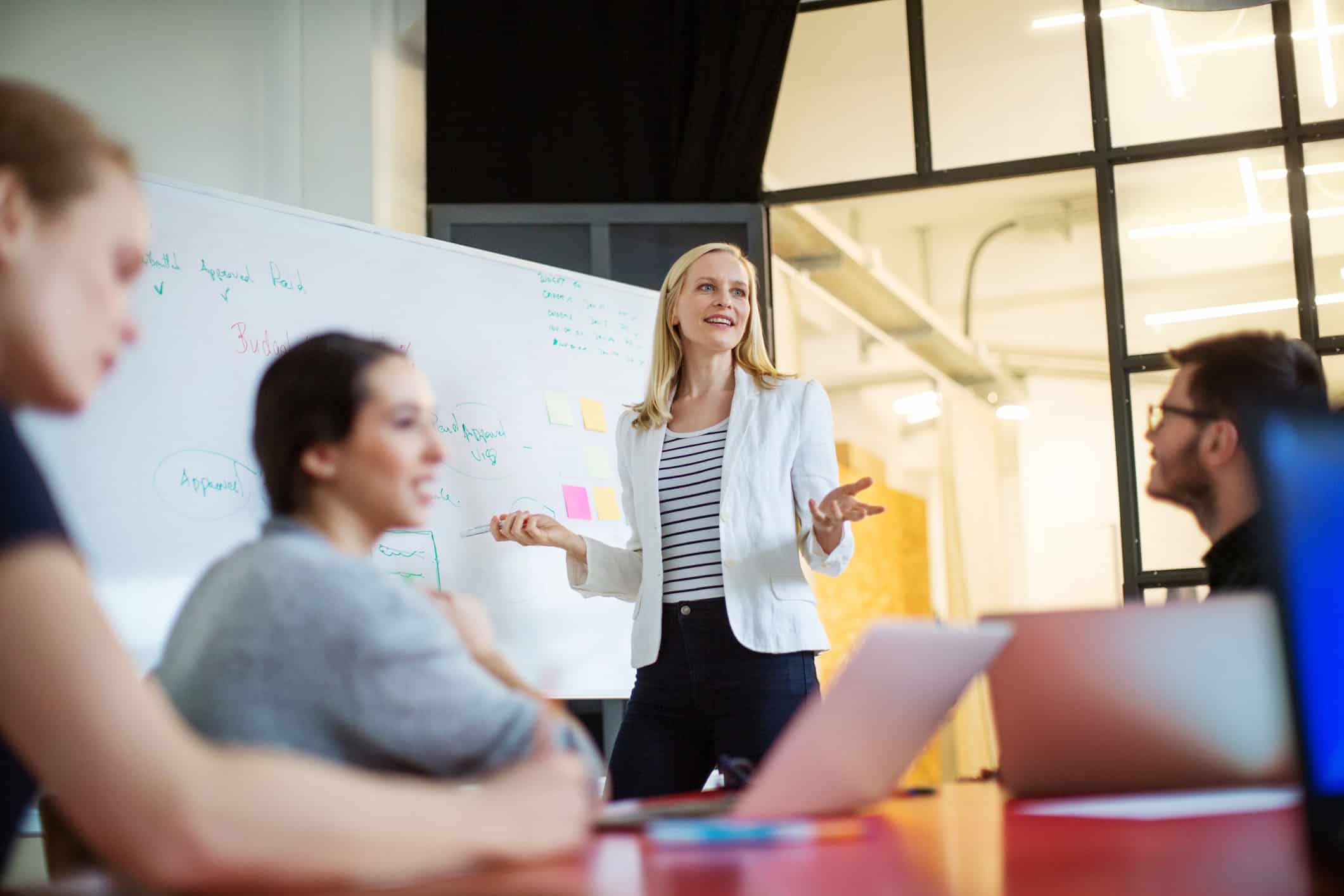 Woman presenting NLP for Law Firms Execution at a whiteboard in a modern office meeting room.