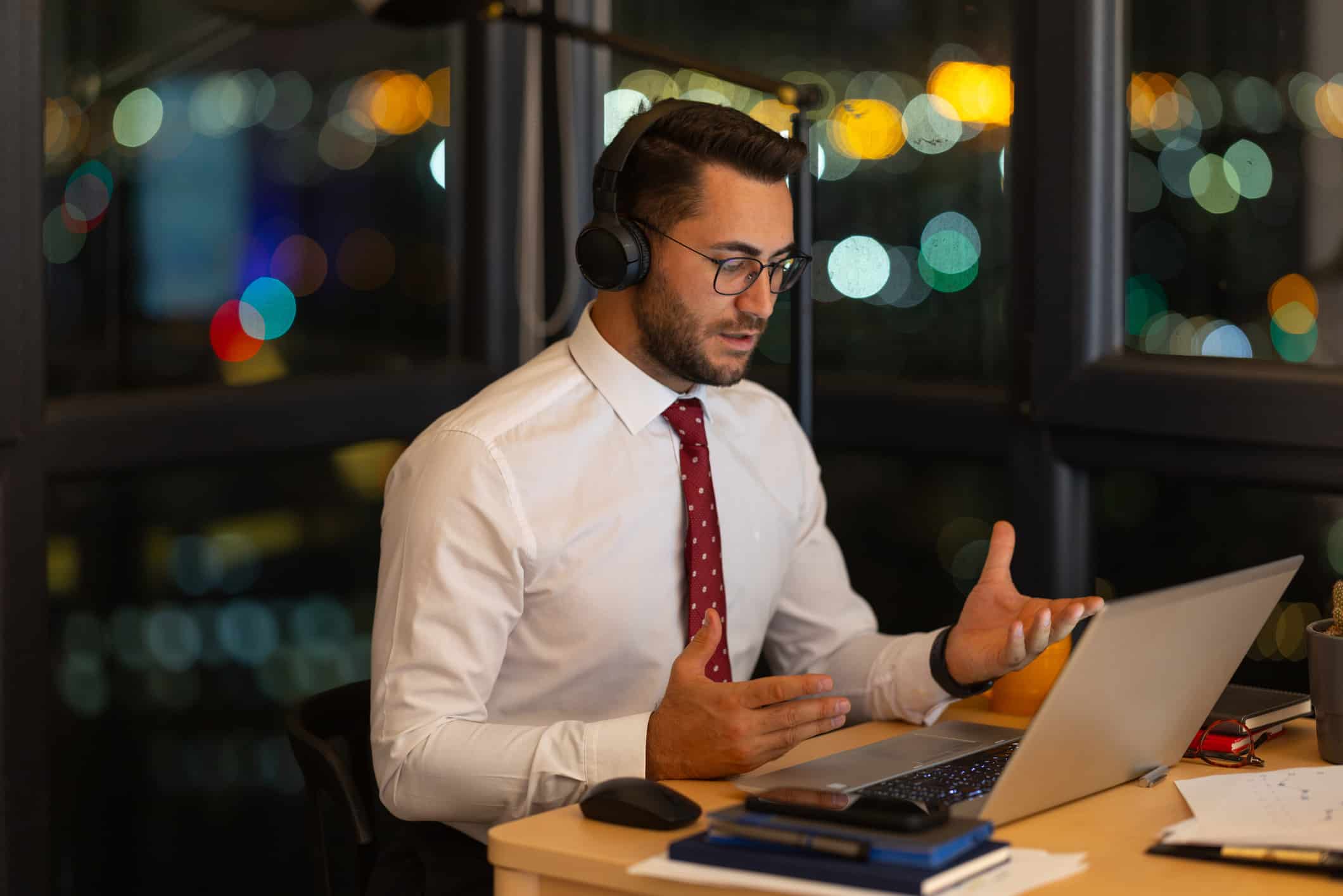 Man in white shirt and tie video calling at night, discussing Law Firm Growth Consulting.