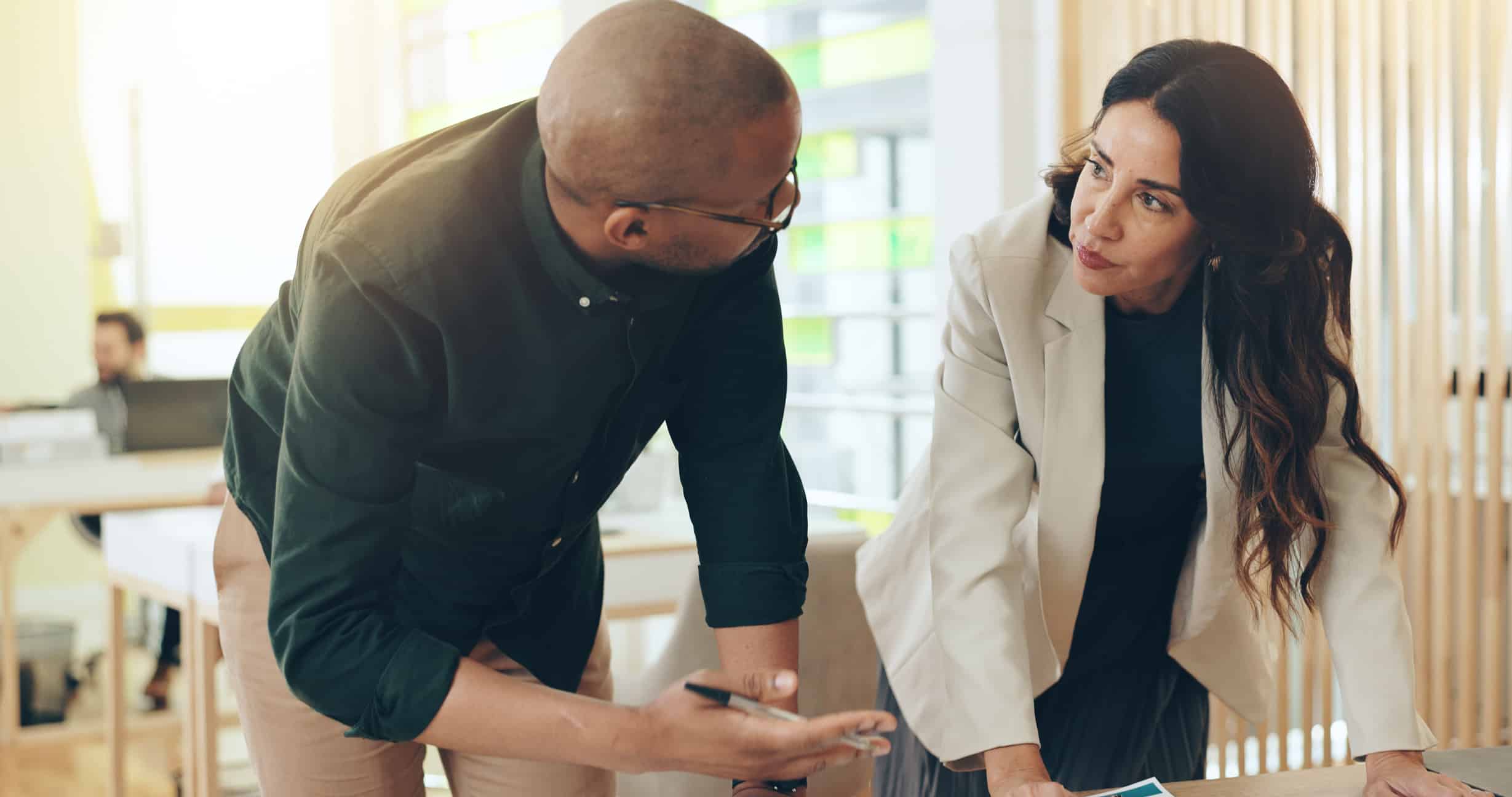 Two eDiscovery Data Analysis Consultants have a serious discussion at a modern office desk.