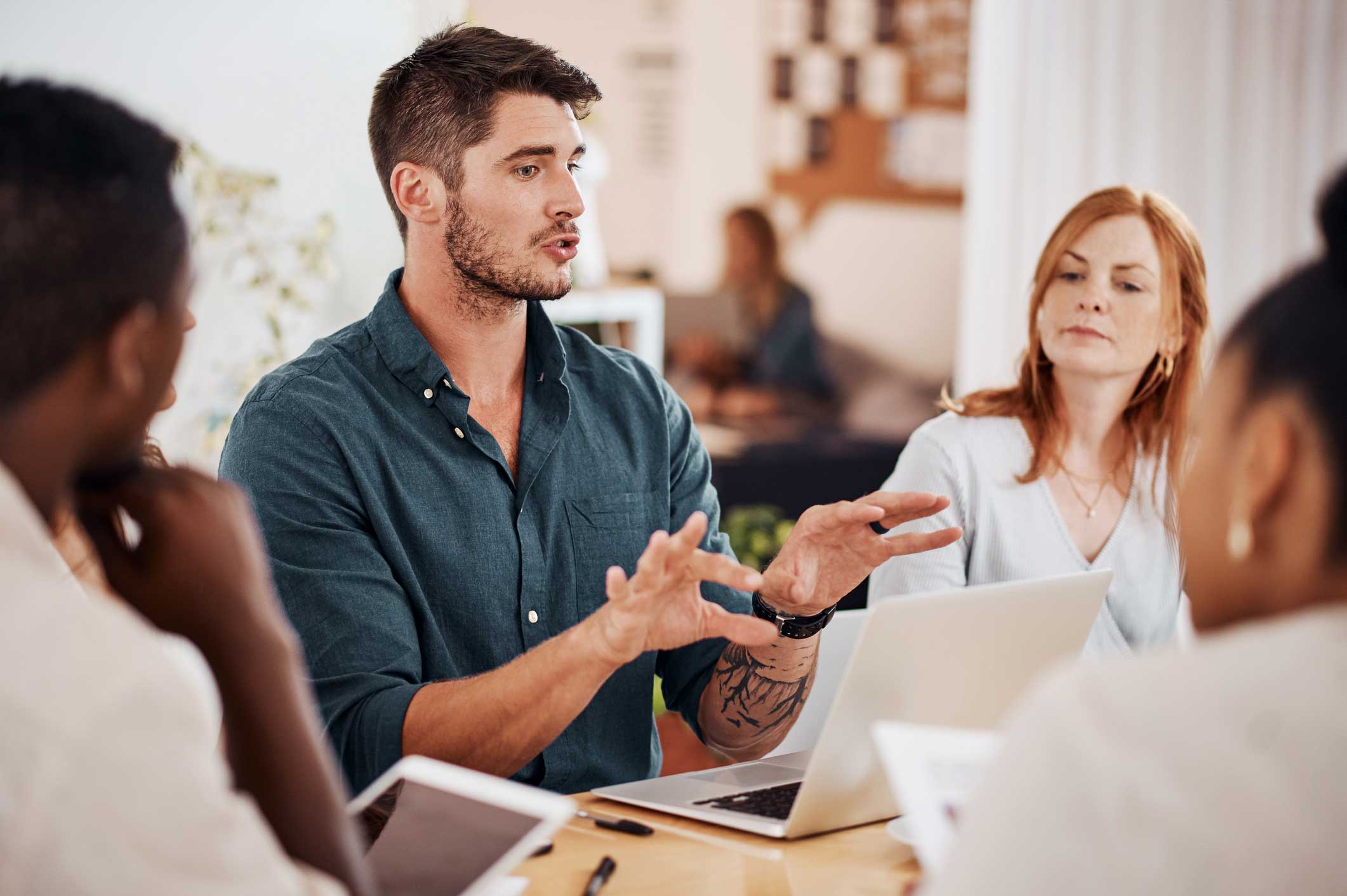 Man discussing Incident Response & Threat Investigations with coworkers during a meeting.
