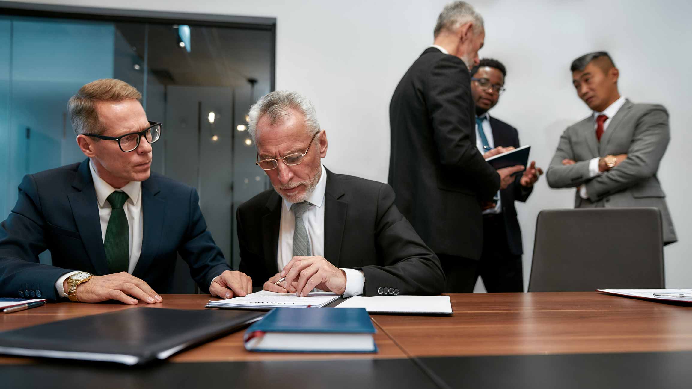 Two businessmen reviewing documents at a table, discussing Document Management Consulting.