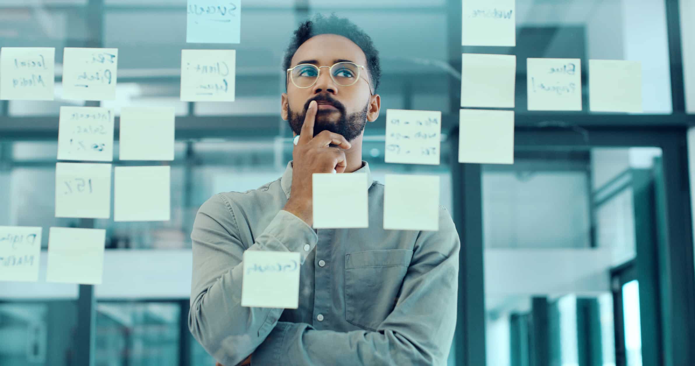 Man thinking while looking at sticky notes—eDiscovery Project Management Consultants at work.