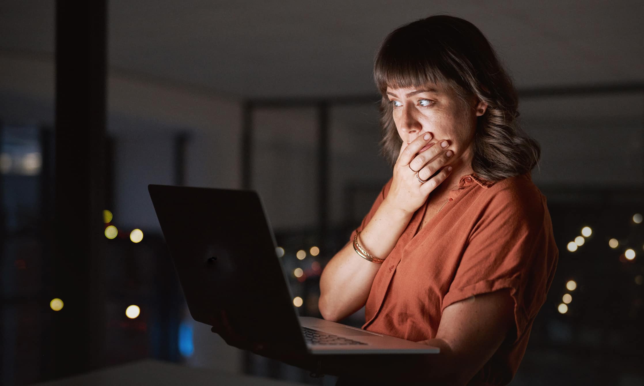 Woman looking at laptop with a shocked expression after reading news from TAR Consulting.