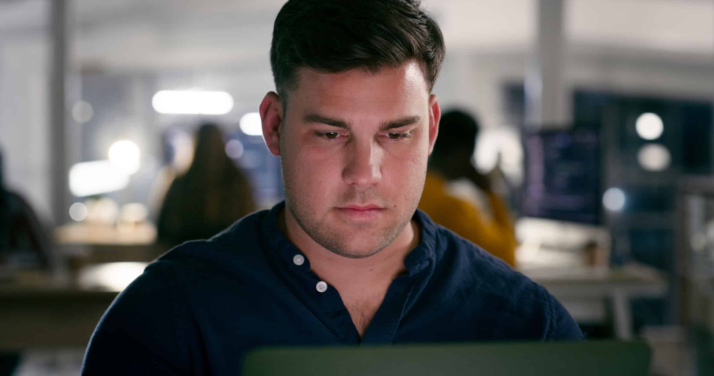 Man working on a laptop in an office, focused on Law Firm Operations Advisory tasks.