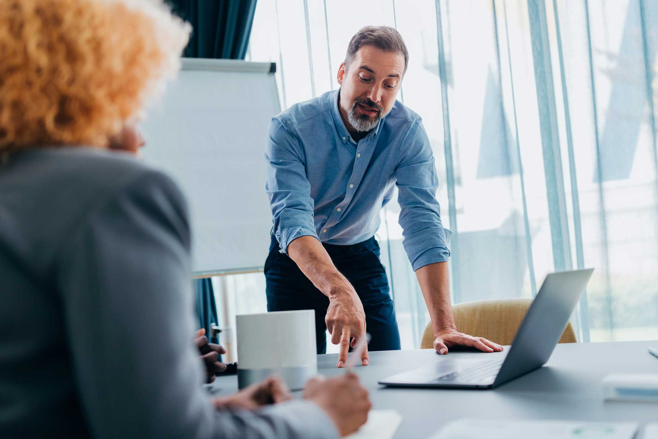 Man pointing at laptop screen during a Law Firm Financial Management meeting with colleagues.