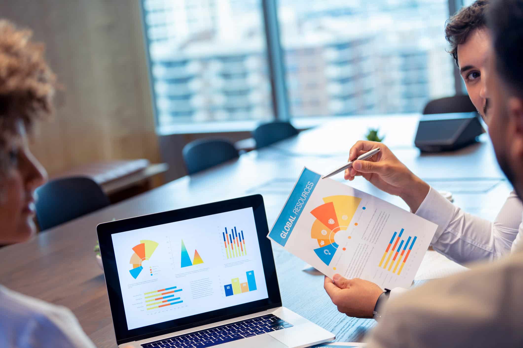 People in meeting discussing Insurance Portfolio Optimization charts and data in an office setting.