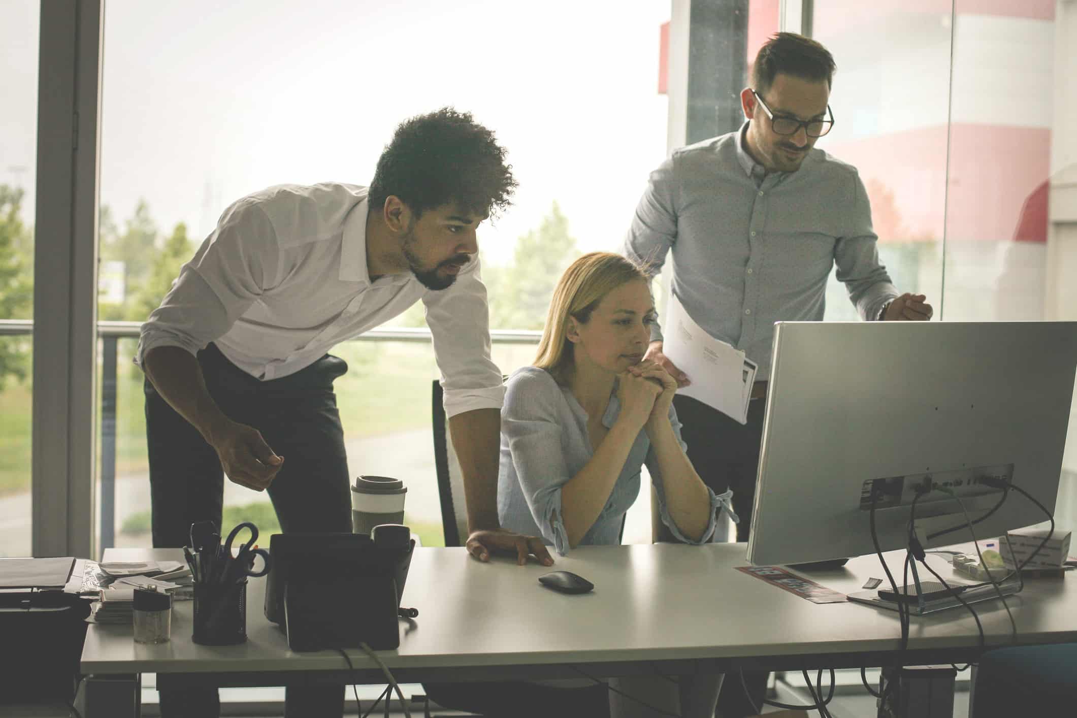 Three colleagues collaborate on Securities Litigation Advisory in modern office with large windows.