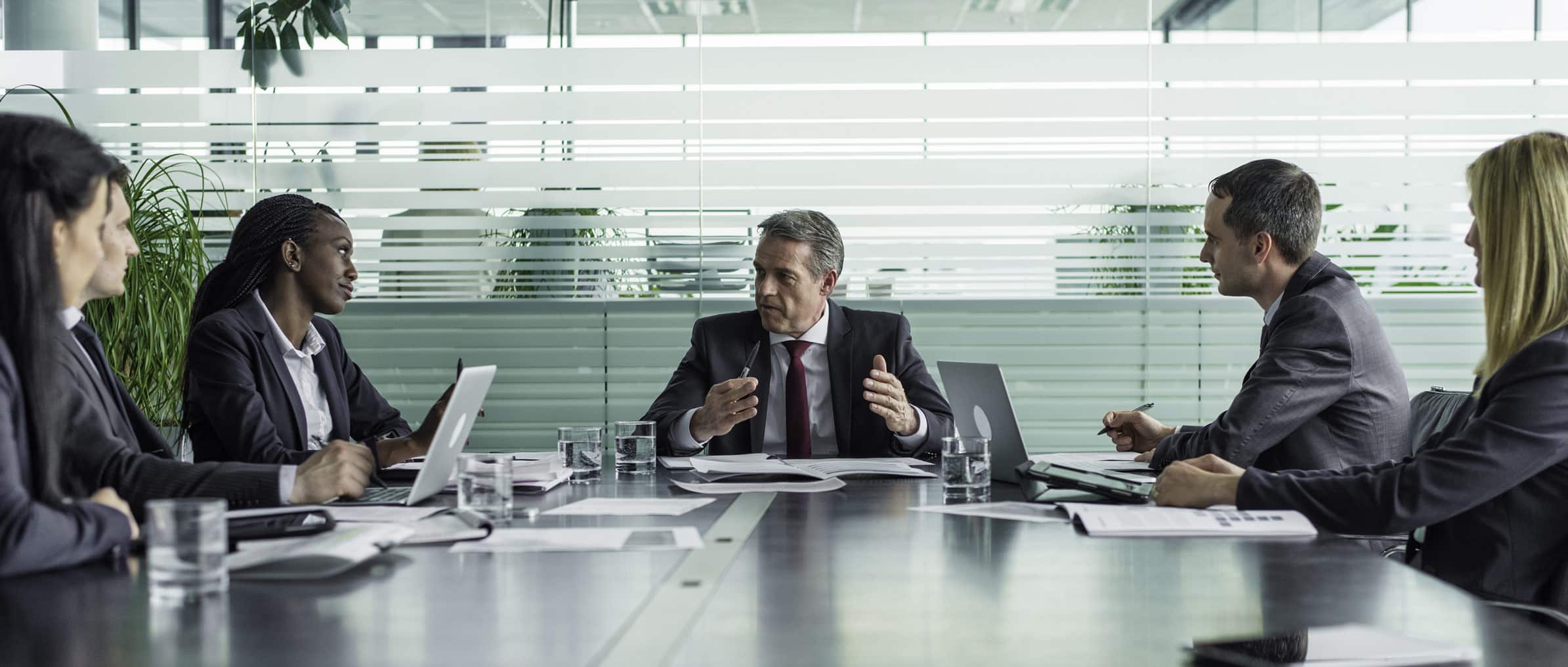 Five businesspeople in a workforce development advisory meeting around a conference table.