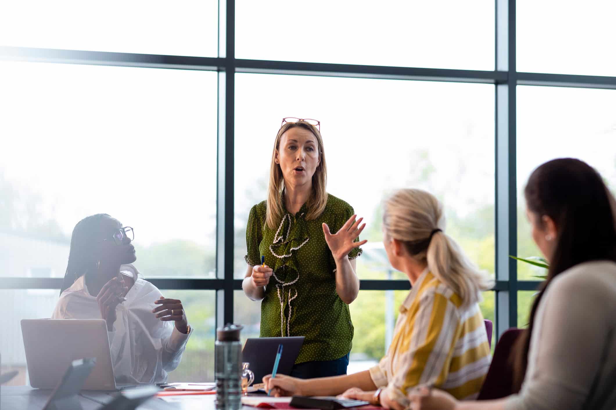Woman leading a meeting at a change management consulting firm in a bright office.