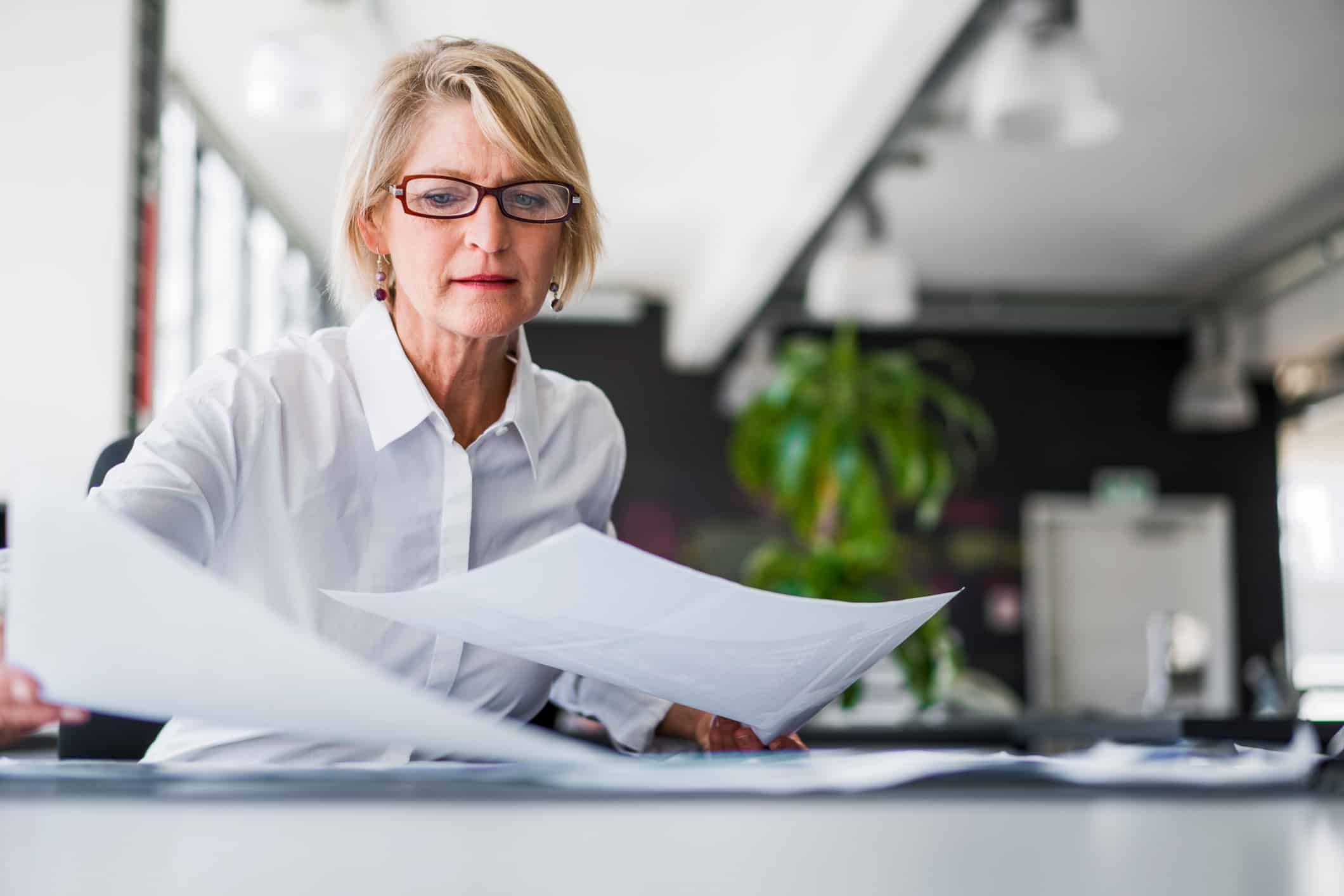 Woman in glasses reviews paperwork, focusing on eDiscovery Document Review Process.