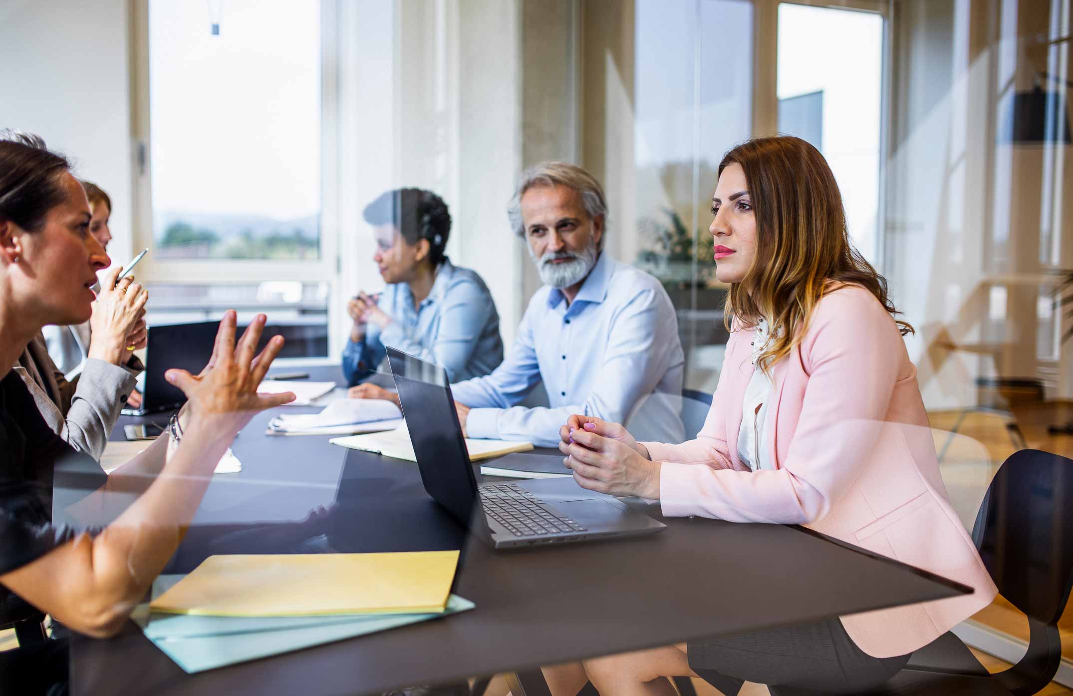 Four people discuss eDiscovery solutions and Artificial Intelligence at a conference table.