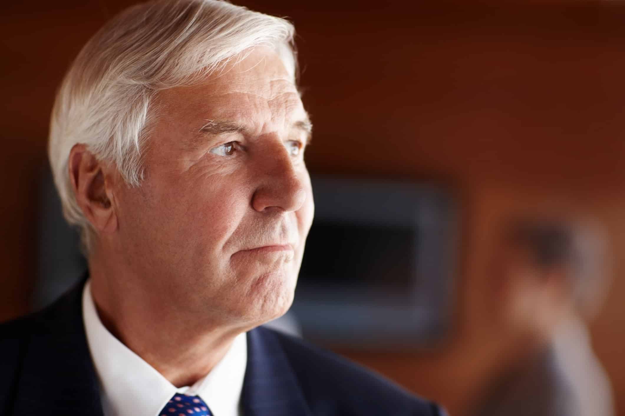 Older man in a suit, thoughtful, with gray hair—ideal for a Securities Litigation Consulting Firm.