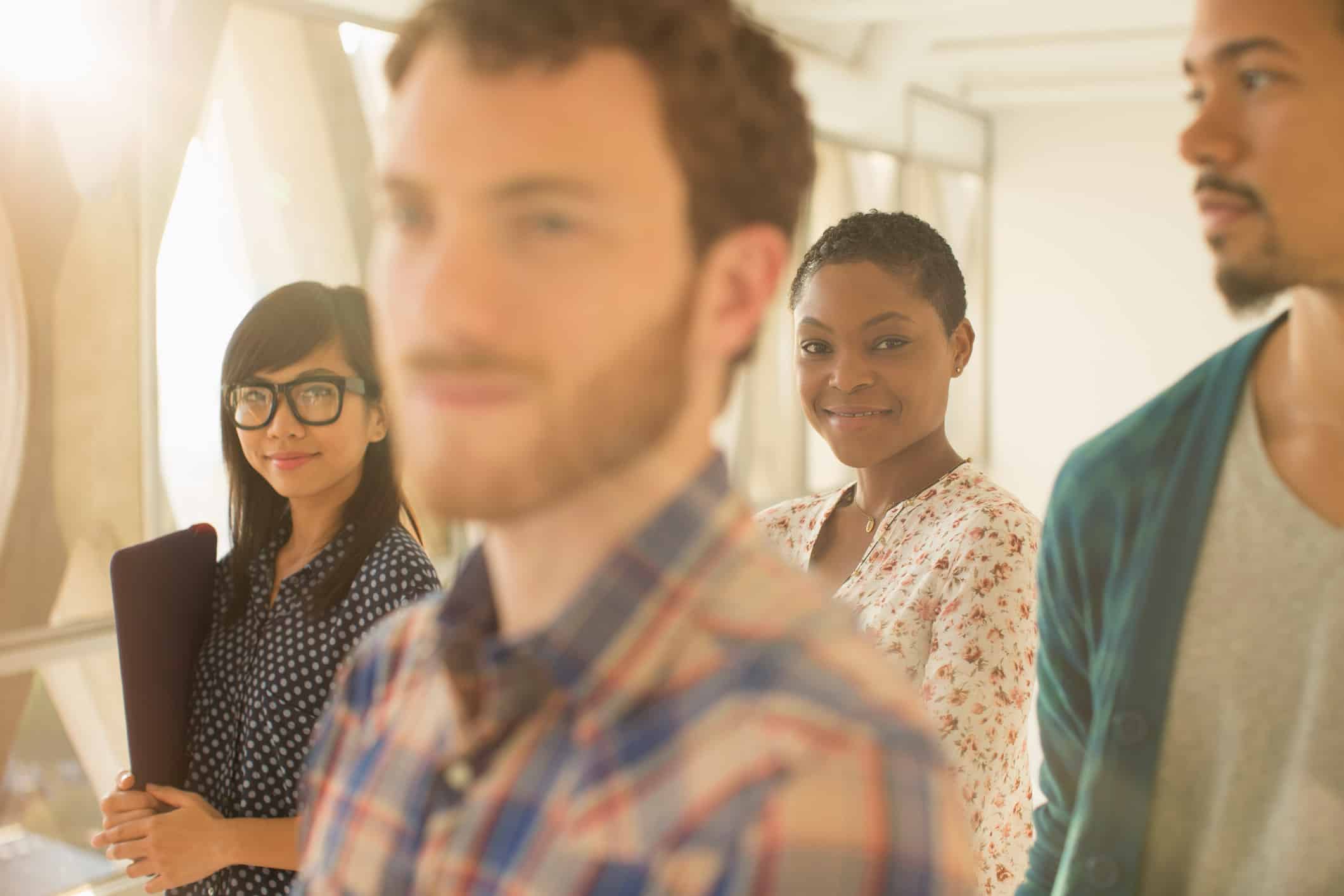 Four young professionals indoors, smiling—showcasing Operational Resilience and Business Continuity.