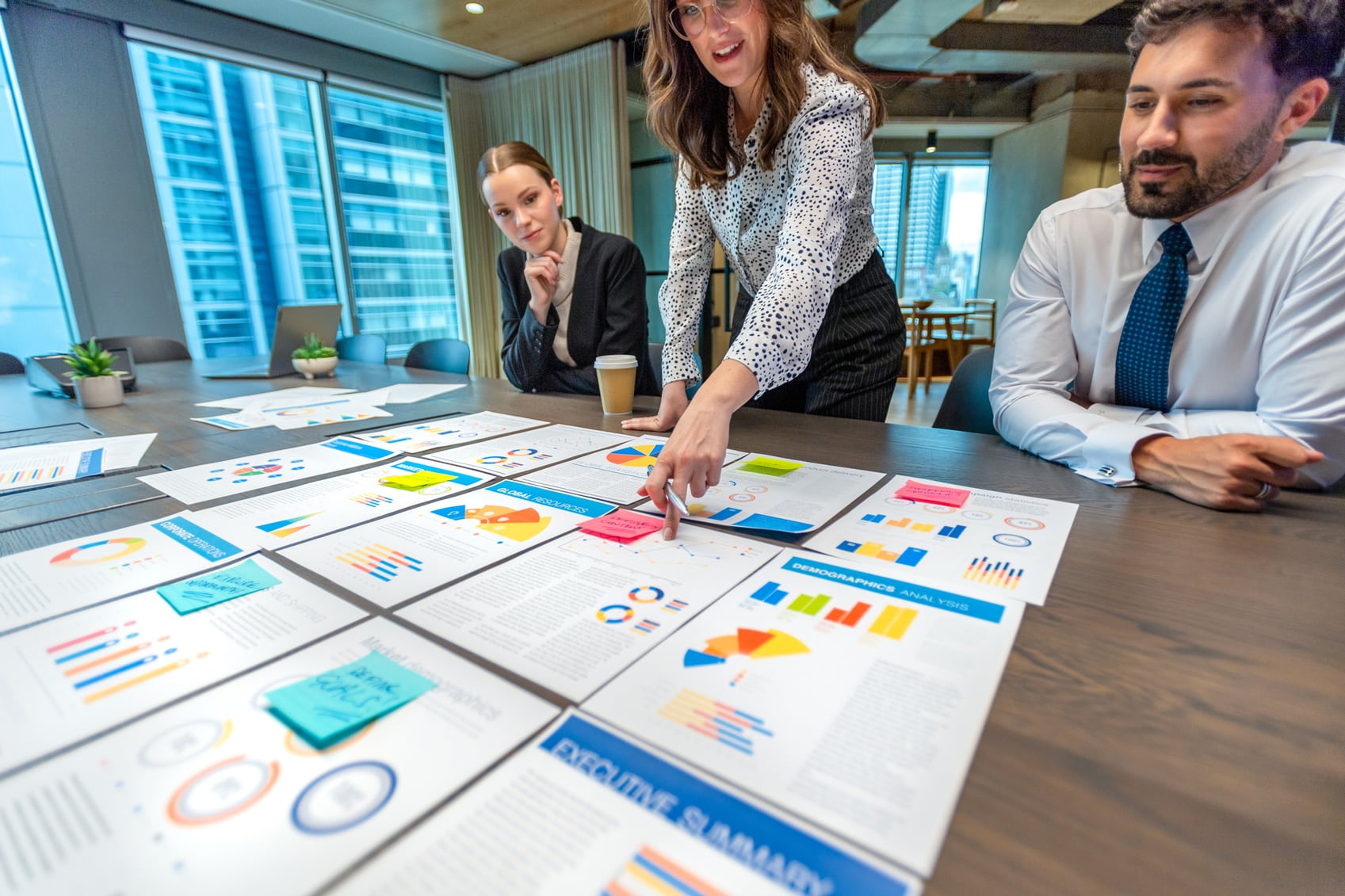 Three professionals discuss performance analytics and colorful charts for continuous improvement.