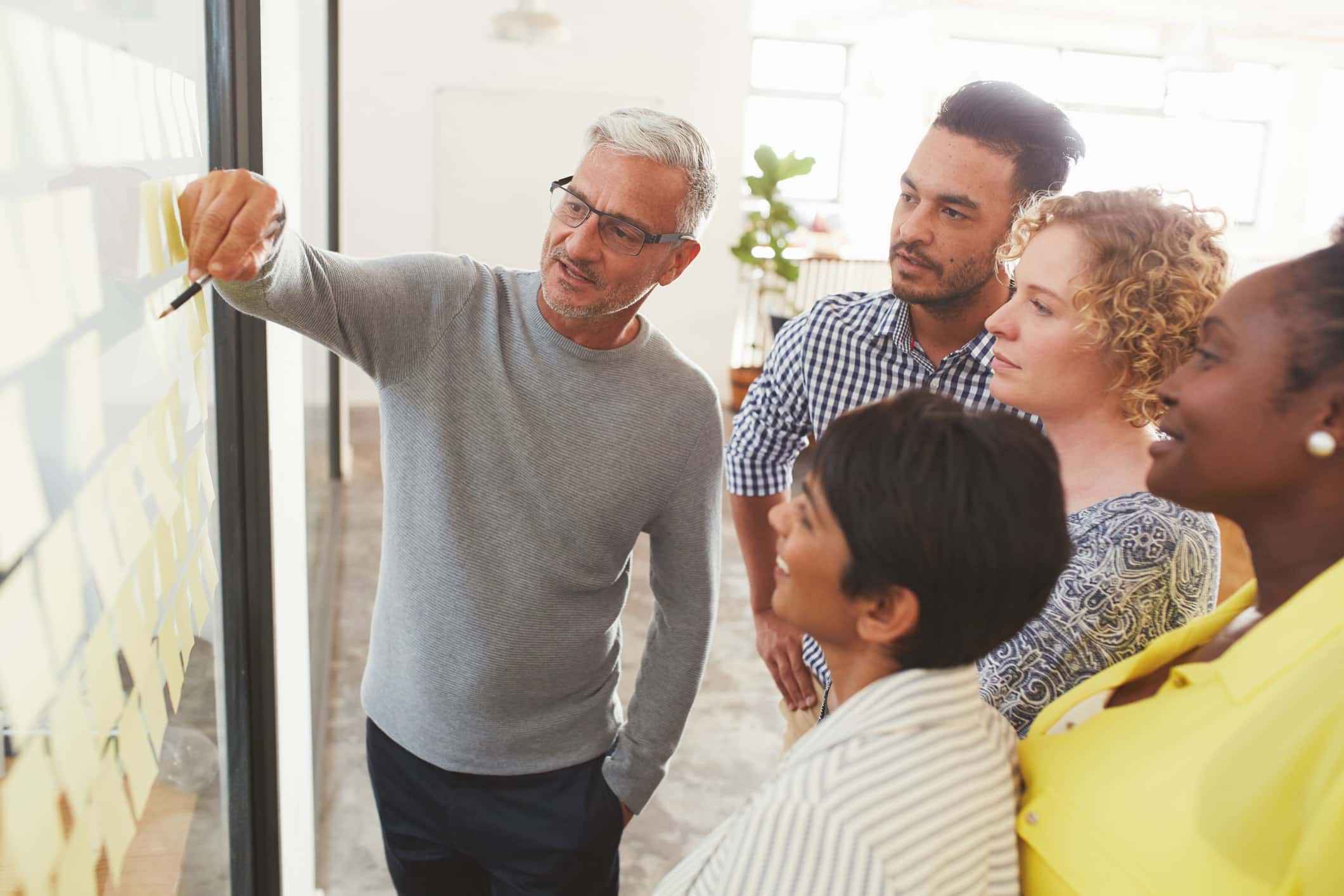 Group watches a man explain eDiscovery project management integration on a glass wall.