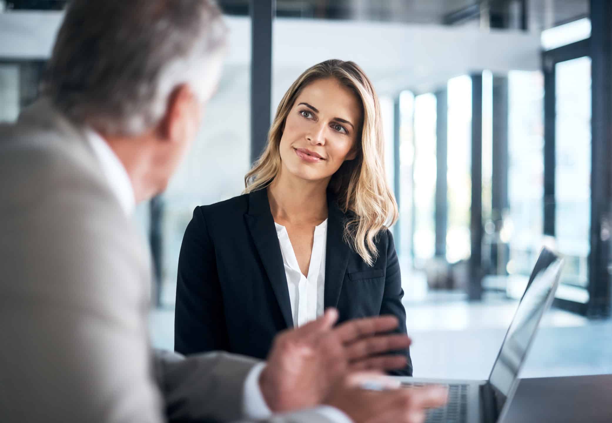 Woman in business attire discusses Data Governance Development in a modern office meeting.